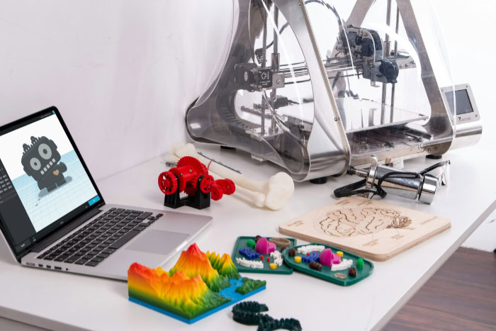 3D printer and laptop with digital model on desk