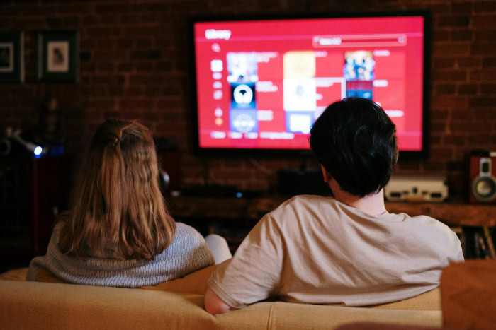 Couple browsing TV streaming menu in living room
