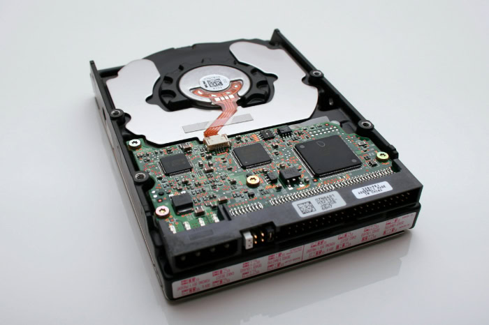 Open hard drive showing circuit board and platter