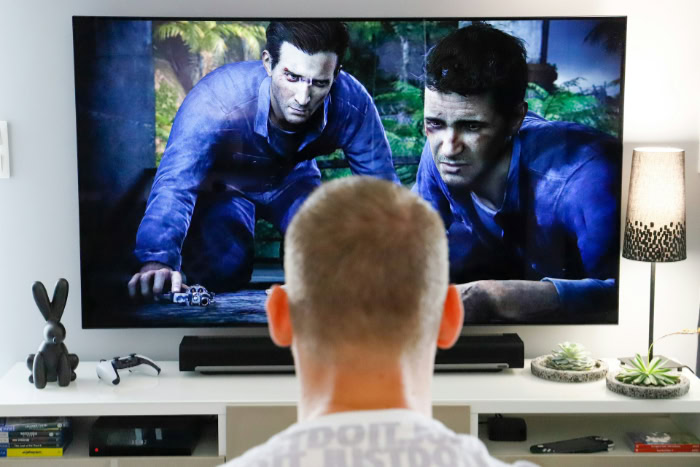 Person gaming on TV with home entertainment setup