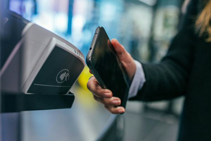 Person paying with smartphone at NFC terminal